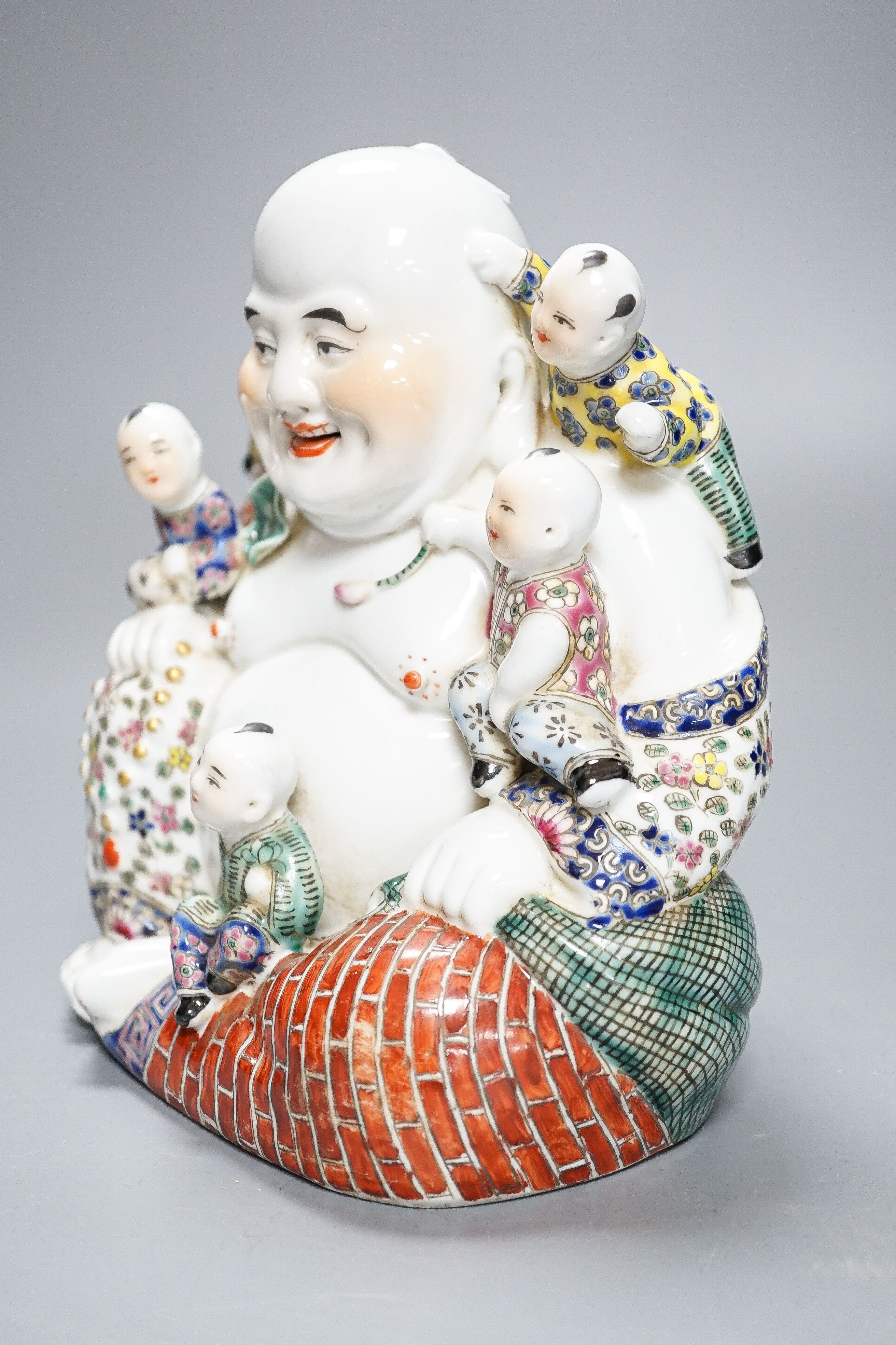 A Chinese enamelled porcelain group of Budai and boys, 19cm high